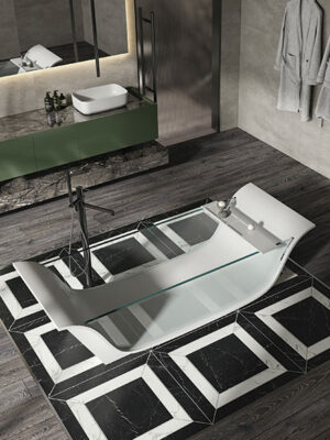 Freestanding bathtub in White Stonage model Chaise Longue Vitrée by MOMA Design, with glass walls and white Stonage holder, flanked by Edition model cabinet