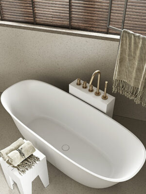 Freestanding bathtub in White Stonage model Grace by MOMA Design, with Tangram accessory and Corian tower for faucets