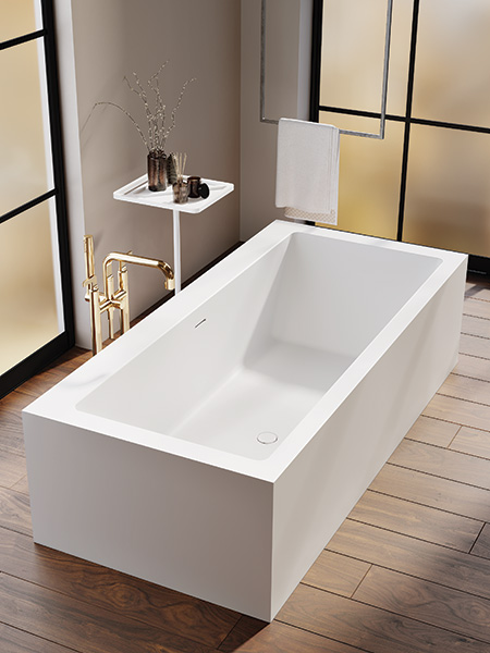 vasca freestanding MOMA Design in Stonage, modello Ivory con uno schienale, affiancata a accessorio Caddy