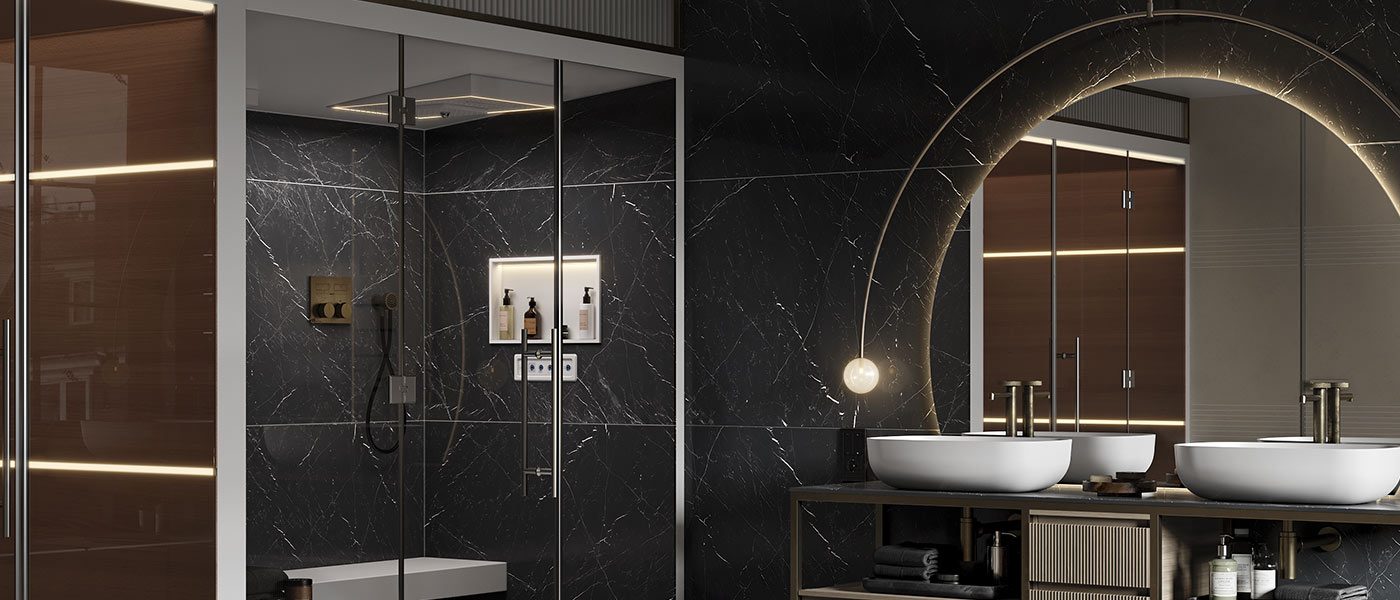 Hammam MOMA Design in Corian modello Comfort ad angolo con panca angolare e pareti rivestite in gres Elegant Black, affiancato a mobile Aria Plus e specchio Mirr Moon